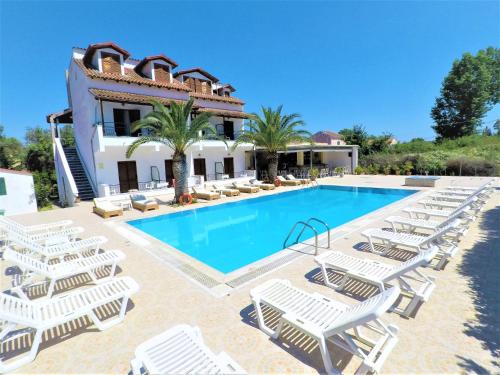 eine Villa mit einem Pool und Liegestühlen in der Unterkunft Captains Studios & Apartments in Kavos