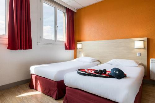リールにあるHôtel de L'UNIVERS LILLEのベッド2台 ホテルルーム 赤いカーテン付