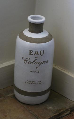 a large white vase sitting on a floor at Chambres et table L' échappée in Bouvesse-Quirieu