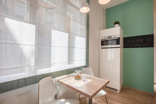 a kitchen with a table and chairs and a refrigerator at Synagogue Apartment Dohány in Budapest