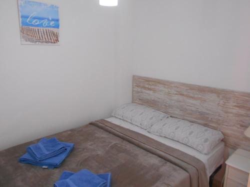 een slaapkamer met een bed met blauwe handdoeken bij Apartamento a la Playa in Algeciras