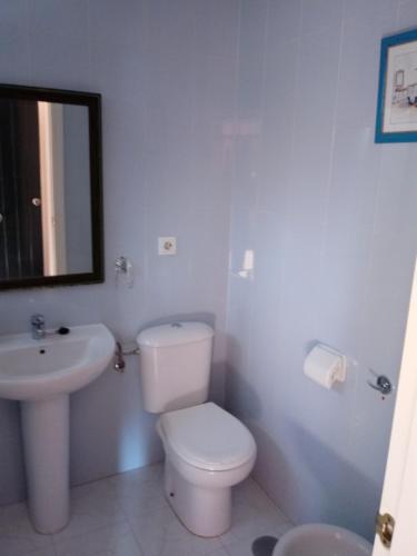 een witte badkamer met een toilet en een wastafel bij Apartamento a la Playa in Algeciras