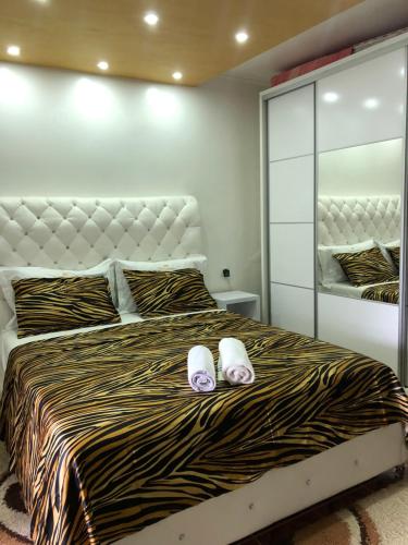 a bedroom with a bed with two slippers on it at Queen Kodre Apartments in Ulcinj
