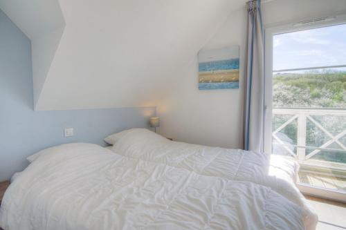 a white bed in a bedroom with a window at Evancy Equihen-Plage in Équihen-Plage
