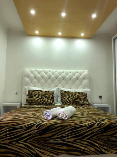 a bedroom with a large bed with two towels on it at Queen Kodre Apartments in Ulcinj