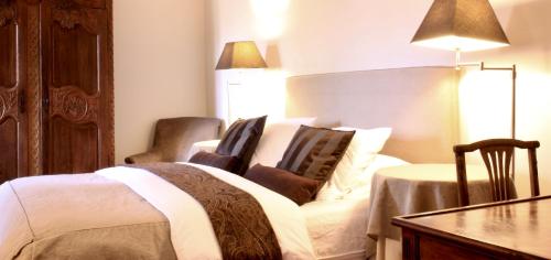 a bedroom with a bed with two chairs and a table at Domaine de Perches in Gaillac