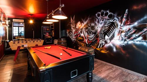 a room with a pool table in front of a wall with graffiti at Hôtel Jolly Roger in Dunkerque