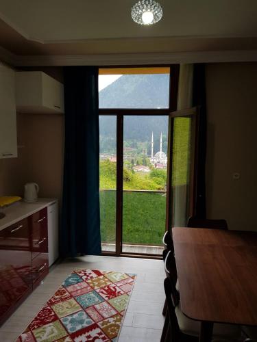 a kitchen with a table and a large window at Uzungol Comfort Residence in Uzungöl