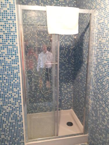 a man standing in a shower in a bathroom at hotel Melissa in Péruwelz