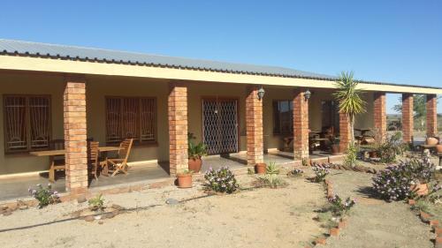 a house with a patio with a table and chairs at Tismaree Guestfarm in Rietoog