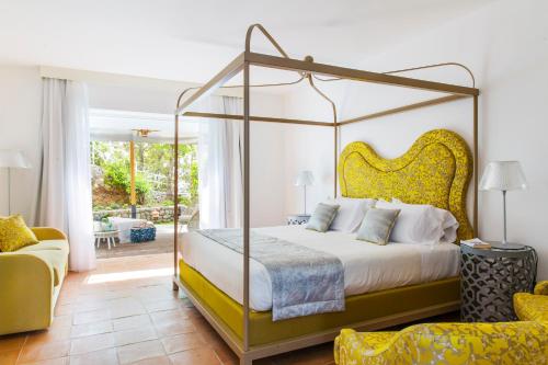 a bedroom with a canopy bed and a couch at Hotel Piccolo Sant'Andrea in Praiano