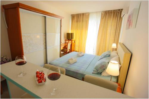 a bedroom with a bed and a table with wine glasses at Apartments Maja in Podstrana