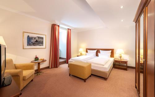 a hotel room with a bed and a chair at Dorint Resort & Spa Bad Brückenau in Staatsbad Brückenau