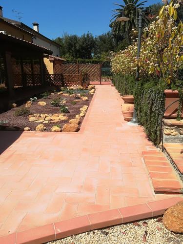 a brick walkway in a garden with plants at Casale la Crocetta in Rosignano Solvay