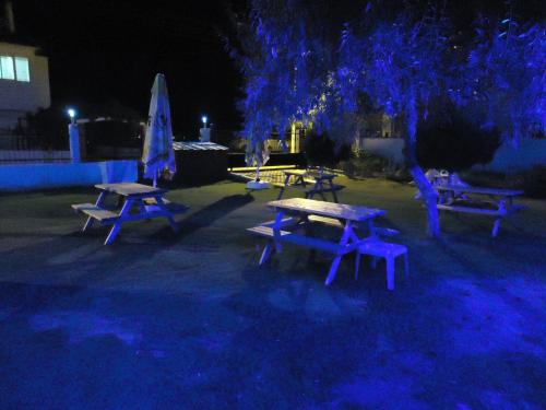 a group of picnic tables and a tree at night at Bells Motel in Seferihisar
