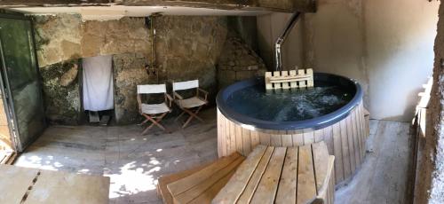 a hot tub in a room with chairs and a table at La Cannara in Marta
