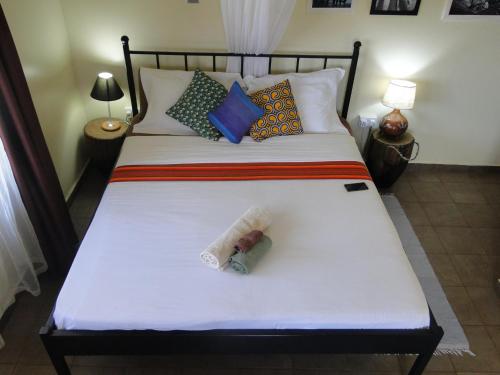 a bedroom with a bed with a bottle on it at Carpe Diem Guesthouse in Entebbe