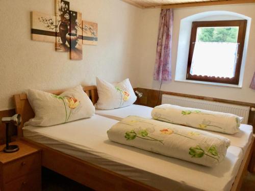 - une chambre avec 2 lits avec des oreillers et une fenêtre dans l'établissement Ferienwohnung Am Grünbach, à Rathen