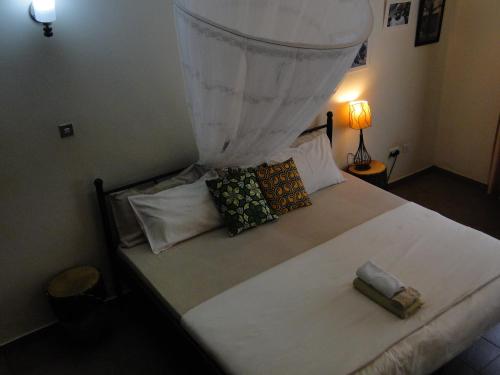 a bedroom with a large white bed with pillows at Carpe Diem Guesthouse in Entebbe