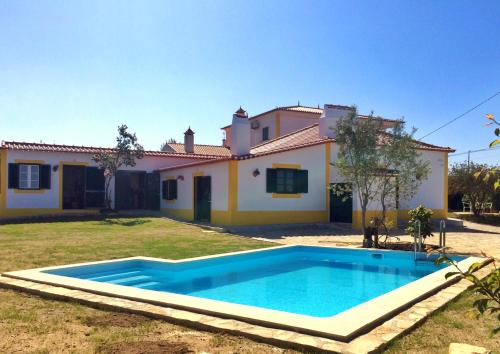 a house with a swimming pool in front of it at Casas da Lagoa in Santo Isidoro