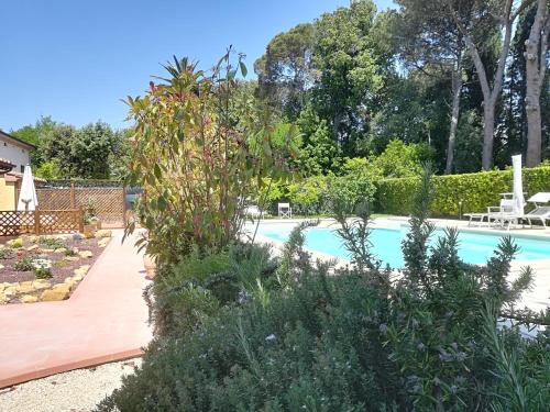 a swimming pool in a backyard with a garden at Casale la Crocetta in Rosignano Solvay