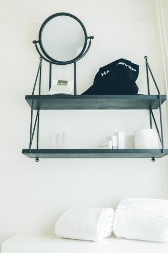 a shelf with a mirror and towels on it at Hotel du Bassin in Ostend