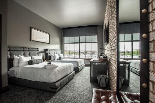 a bedroom with two beds and a large window at Ironworks Hotel Indy in Indianapolis