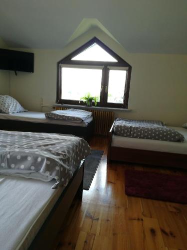 a bedroom with two beds and a window at Pokoje Gościnne Lawenda in Sandomierz
