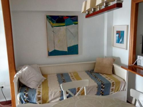 a small bedroom with a bed and a chair at Marenostrum view in Playa Pobla de Farnals