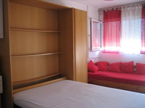 カルノン・プラージュにあるNeptuniaのベッドルーム1室(ベッド1台、窓に赤いソファ付)