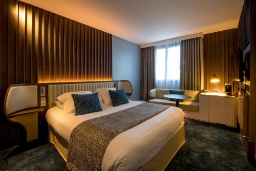 a hotel room with a large bed and a desk at Best Western Premier Hotel de la Paix in Reims