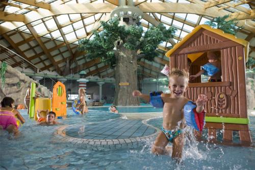 a young child playing in a swimming pool at Mobile Homes and Apartment - Terme Čatež in Čatež ob Savi