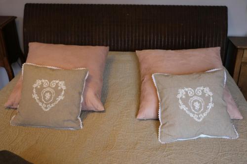 a bed with two pillows at Chambres et table L' échappée in Bouvesse-Quirieu