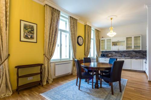 comedor con paredes amarillas, mesa y sillas en Karlsbad Prestige, en Karlovy Vary