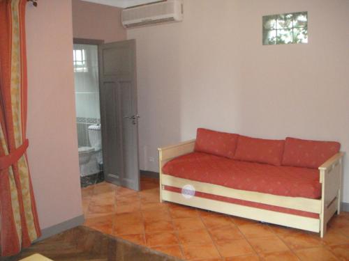 uma sala de estar com um sofá vermelho num quarto em Auberge des Lices em Carcassonne