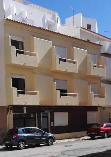 a blue car parked in front of a building at Armação Beach Residences in Armação de Pêra