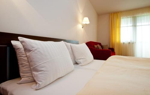 a hotel room with a bed with white pillows at Penzion Ravence in Liptovský Trnovec