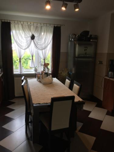 a kitchen with a table and chairs and a window at POKOJE GOŚCINNE RENATA KNITTER in Komnino