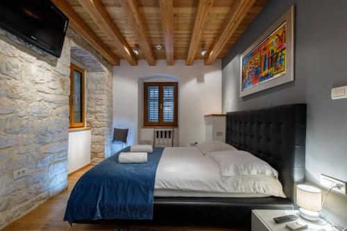 a bedroom with a large bed and a stone wall at Villa Marta in Split