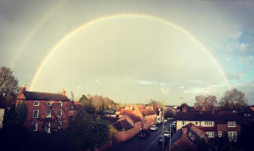 un arco iris en el cielo sobre una ciudad en Tudor Farm B&B, en Elston