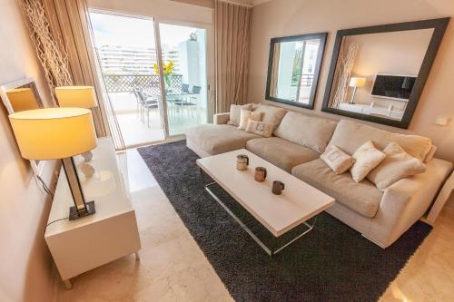 salon z kanapą i stołem w obiekcie VACATION MARBELLA I Brand New Terrazas de Banús Apt, 24-7 Security, a minute from the Marina, The Sea and Luxury Shopping w Marbelli
