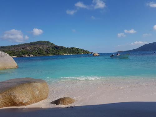 a boat in the water on a beach at Tranquility villas in Baie Sainte Anne