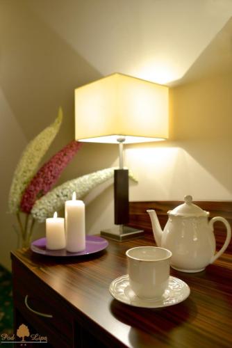 a table with a lamp and a tea pot and candles at Zajazd Pod Lipą in Humniska