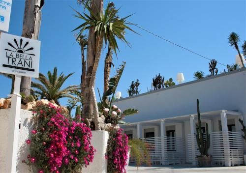 a hotel with pink flowers in front of a building at La Bella Trani - Suites and B&B in Trani