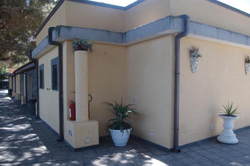 a building with potted plants on the side of it at Hotel Al Togo Fitness & Relax in Vulcano