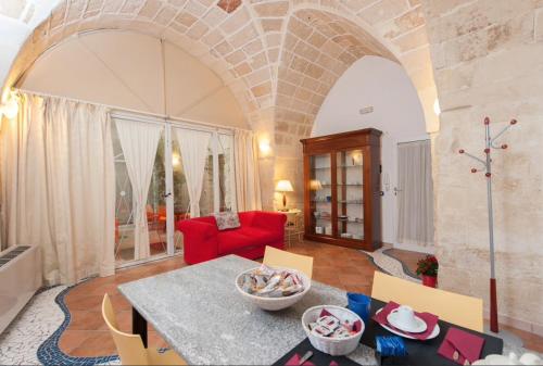 a living room with a table and a red couch at Corte dei Memoli in Lecce