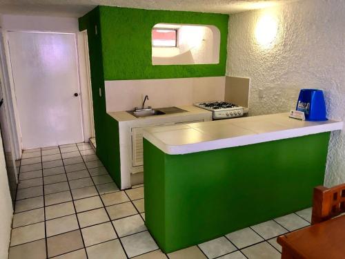 a green and white kitchen with a sink and a stove at Suites Santa Barbara in Manzanillo