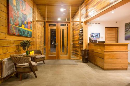 a lobby with wood paneling and a wooden wall at Maki Hotel in Pucón