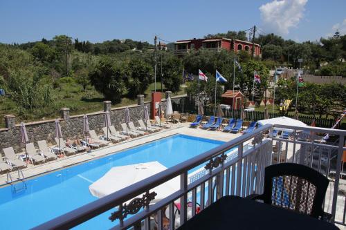 a balcony with a swimming pool with lounge chairs at Rainbow in Arillas