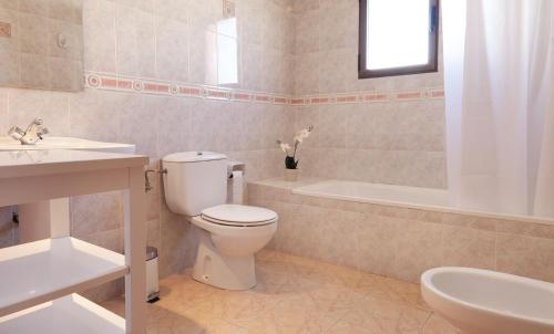 a bathroom with a toilet and a tub and a sink at Villas Los Olivares - Deniasol in Els Poblets